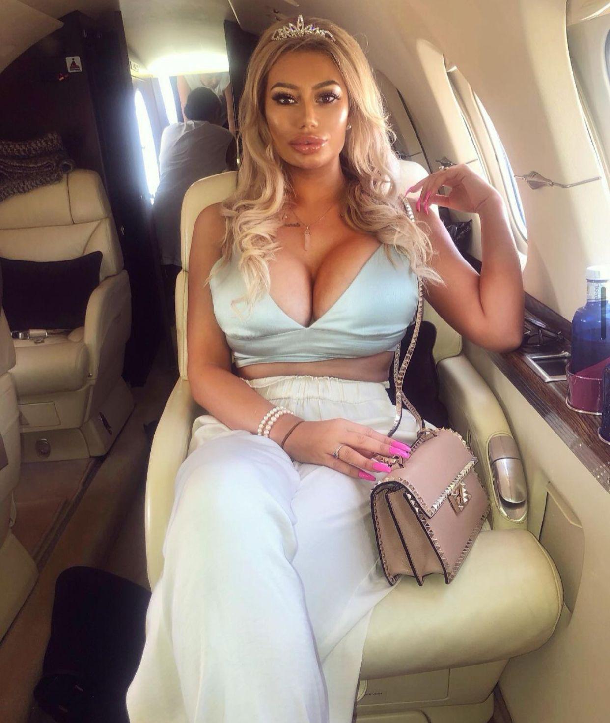Sophie on a private jet  in a blue dress 