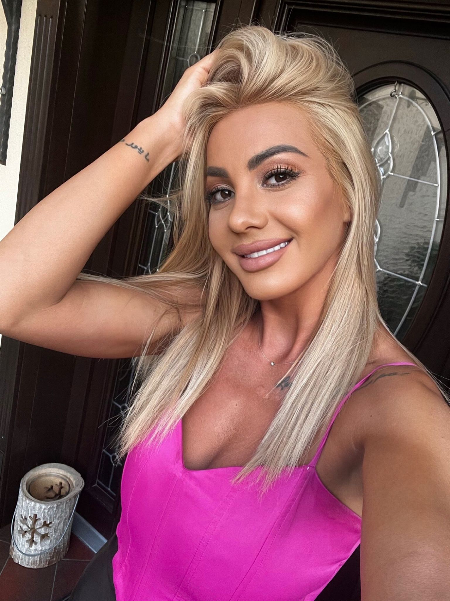 Alice taking a selfie in a pink top 