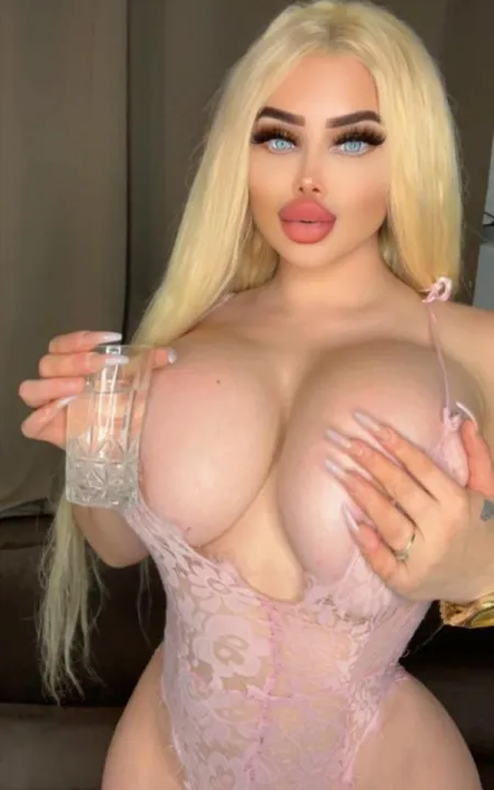Analisa sipping a drink while showing you her breasts