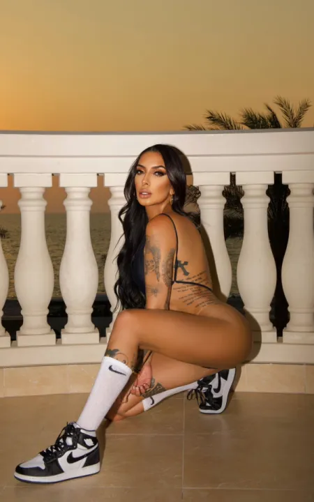 Meghan kneeling down on the balcony in her lingerie 