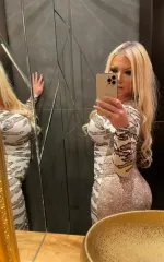 A mirror selfie of Barbie wearing a snake skin dress, showing off her ass. 