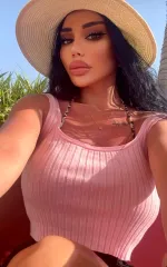 Leila taking a selfie in a summer hat and pink top. 