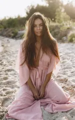 Kira wearing a loose pink dress on the beach 