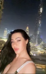 Sandra taking a selfie in front of some night city lights 
