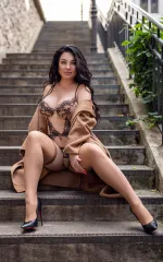 Alisa sitting on a flight of stairs in skin coloured lingerie 