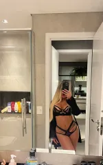 Nicole taking a selfie in the mirror while rocking a black set of lingerie 