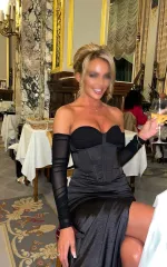 Gracie sitting in a restaurant while wearing a black dress 