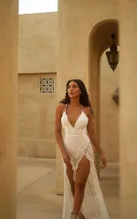 Melanie walking while wearing a long, white dress 