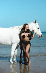 Luana standing next to a white horse 