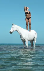 Luana standing on a white horse 