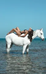 Luana laying on a white horse 