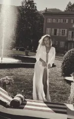 Jayla standing in front of the fountain in a long white robe 