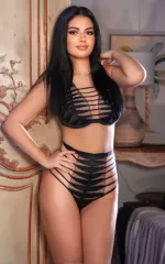 Vivian standing in a set of black lingerie 