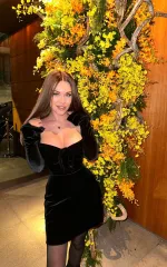Gianna standing in a small velvet black dress