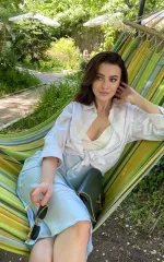 Roxana sitting in a hammock while wearing a white shirt 