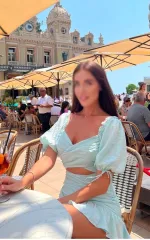 Alexsa sitting at a table in italy while drinking a champagne