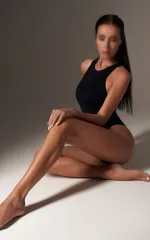 Alexsa sitting down while wearing a black leotard